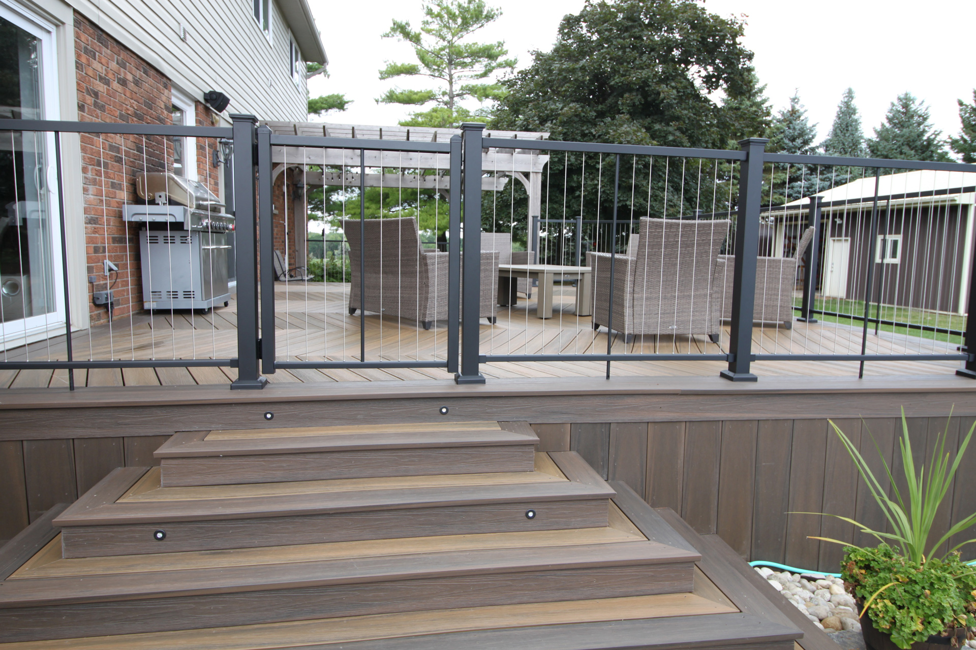 Deck stairs leading up to a deck with gated railing