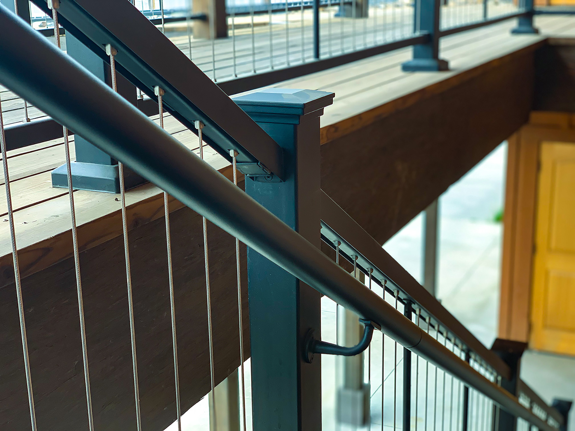 Close-up of a horizontal steel deck railing with integrated lighting on a modern porch